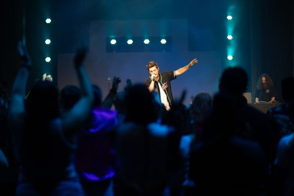 Singer performing on stage with crowd cheering.