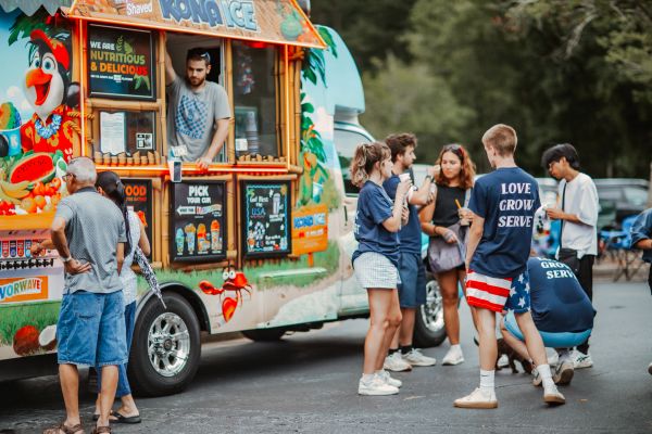 People gathered around a colorful Kona Ice truck.