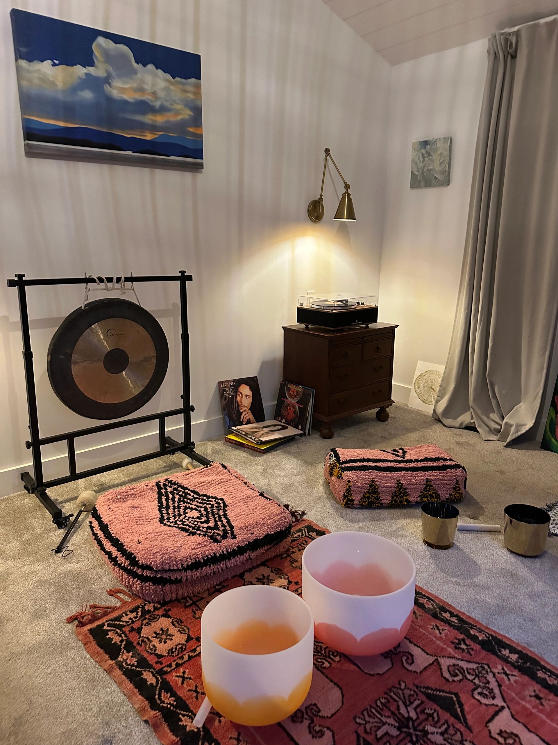 Cozy meditation corner with cushions, a gong, and a record player.