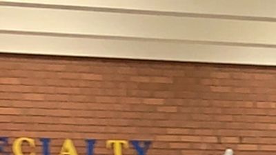 Partial view of a brick wall with letters.