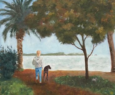 A man and his Great Dane walk by the bay in the shade of fall trees as a squirrel distracts his dog.