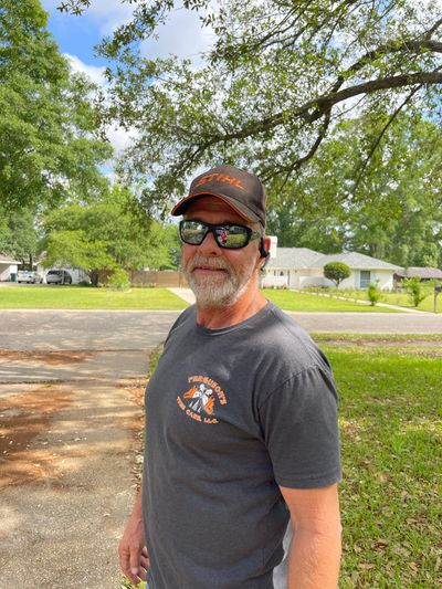 Carl Ferguson, a licensed arborist, standing beside a large tree during a property evaluation. 