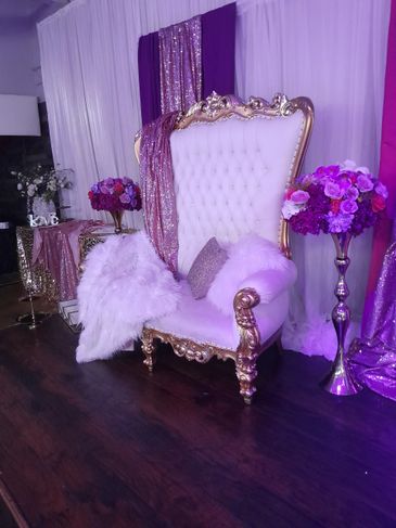 Luxurious white and gold throne chair with purple floral decor.