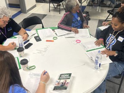 Group of people reviewing documents around a table.