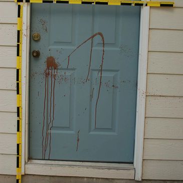 Blue door with brown liquid splattered and dripping down.