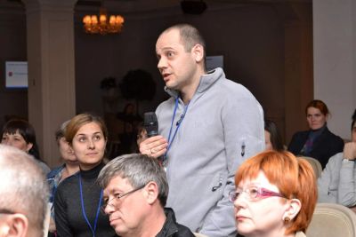 Чоловік задає питання на конференції.