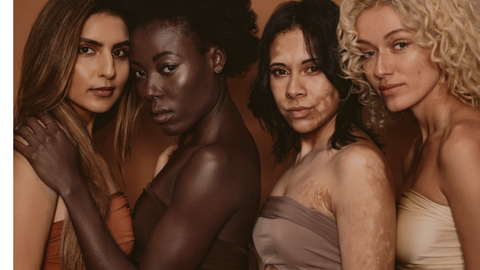 Portrait of four diverse women showcasing natural beauty and various skin tones.