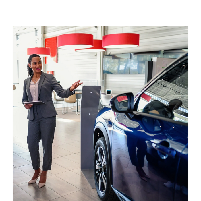 A car salesperson presenting a blue car inside a showroom.