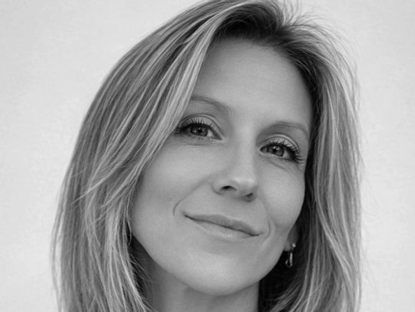 Black and white portrait of a woman with a gentle smile and light hair.