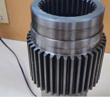 Close-up of a metallic gear with inner and outer teeth.