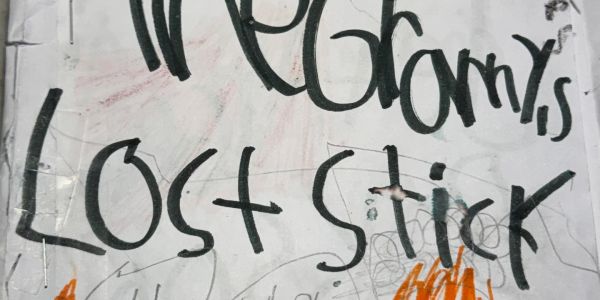 Handwritten lost stick sign with bold black letters on white paper.