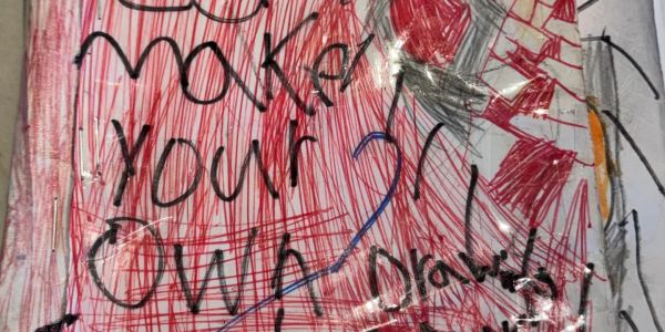 A colorful, handwritten sign encouraging creativity with 'make your own drawing'.