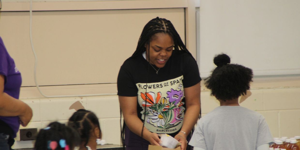 Woman engaging with children in a classroom or activity setting.