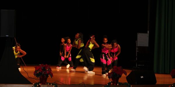 Young girls performing a hip-hop dance on stage.