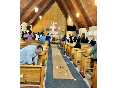 People gathered inside a church with decorations along the aisle.