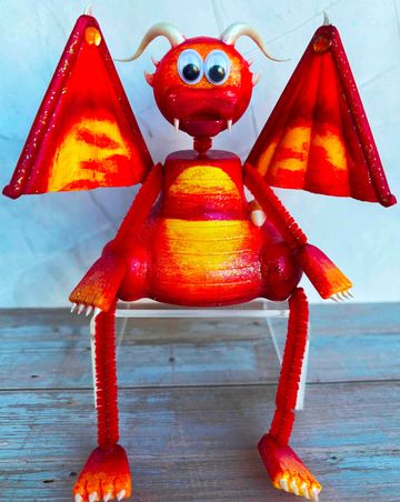 Red and orange dragon figurine with big eyes and wings.