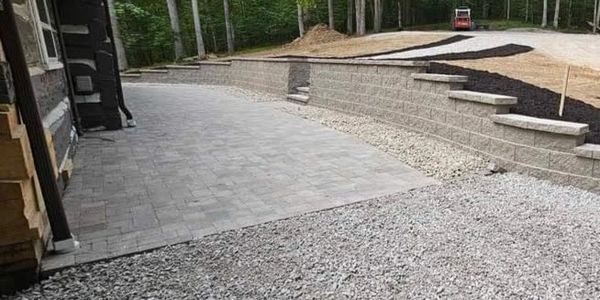 Newly paved driveway and retaining wall under construction.