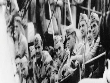 A group of soldiers in uniform leaning on a railing, likely from a historical wartime period.