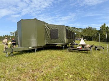 Military tent setup in grassy field