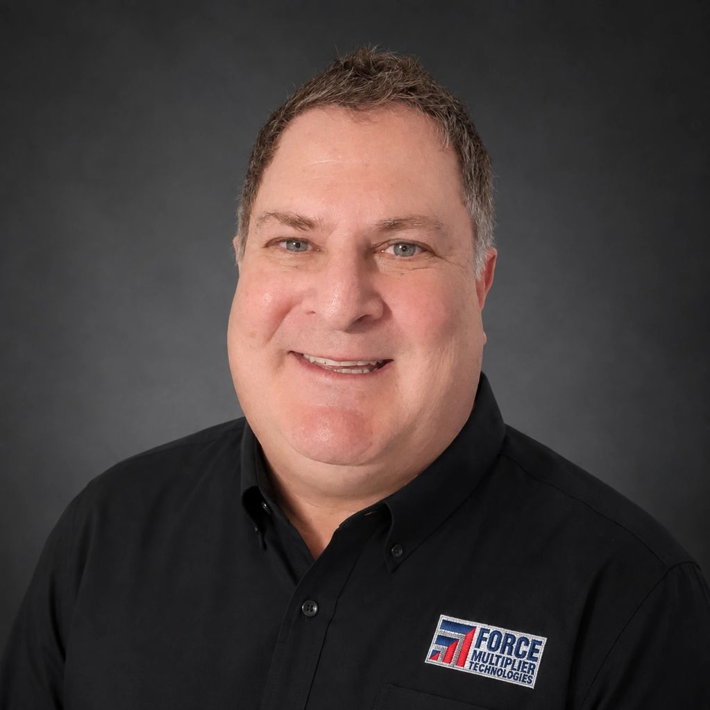 Middle-aged man smiling in a Force Multiplier Technologies shirt.