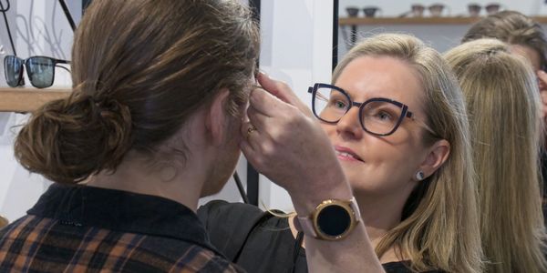 One of our team members helping try-on glasses