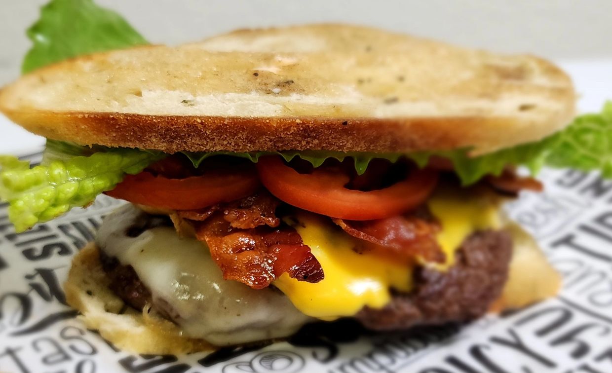 Classic Melt:2 smash patties, grilled sourdough, bacon, 2 cheeses, tomato, lettuce, Classic Sauce