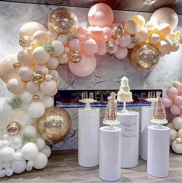 Elegant balloon arch with pink, white, and gold balloons at a birthday celebration.