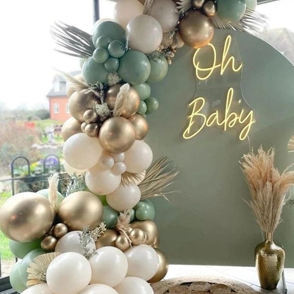 Elegant baby shower setup with gold, white, and mint balloons and a neon 'Oh Baby' sign.