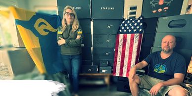 Two people in a warehouse with donated supplies for Ukraine