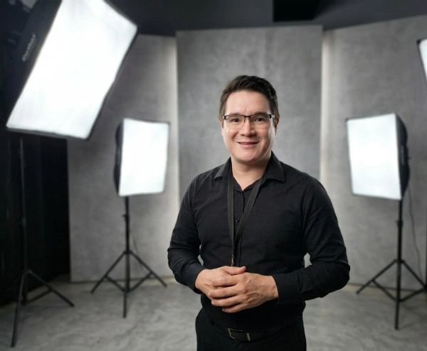 Man smiling in a photography studio with studio lights.
