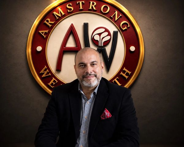 Man posing in front of Armstrong Wealth logo.