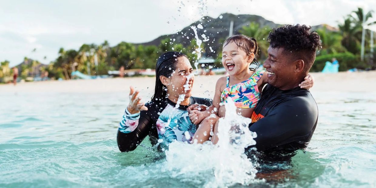 Family enjoying fun time splashing water at the beach.