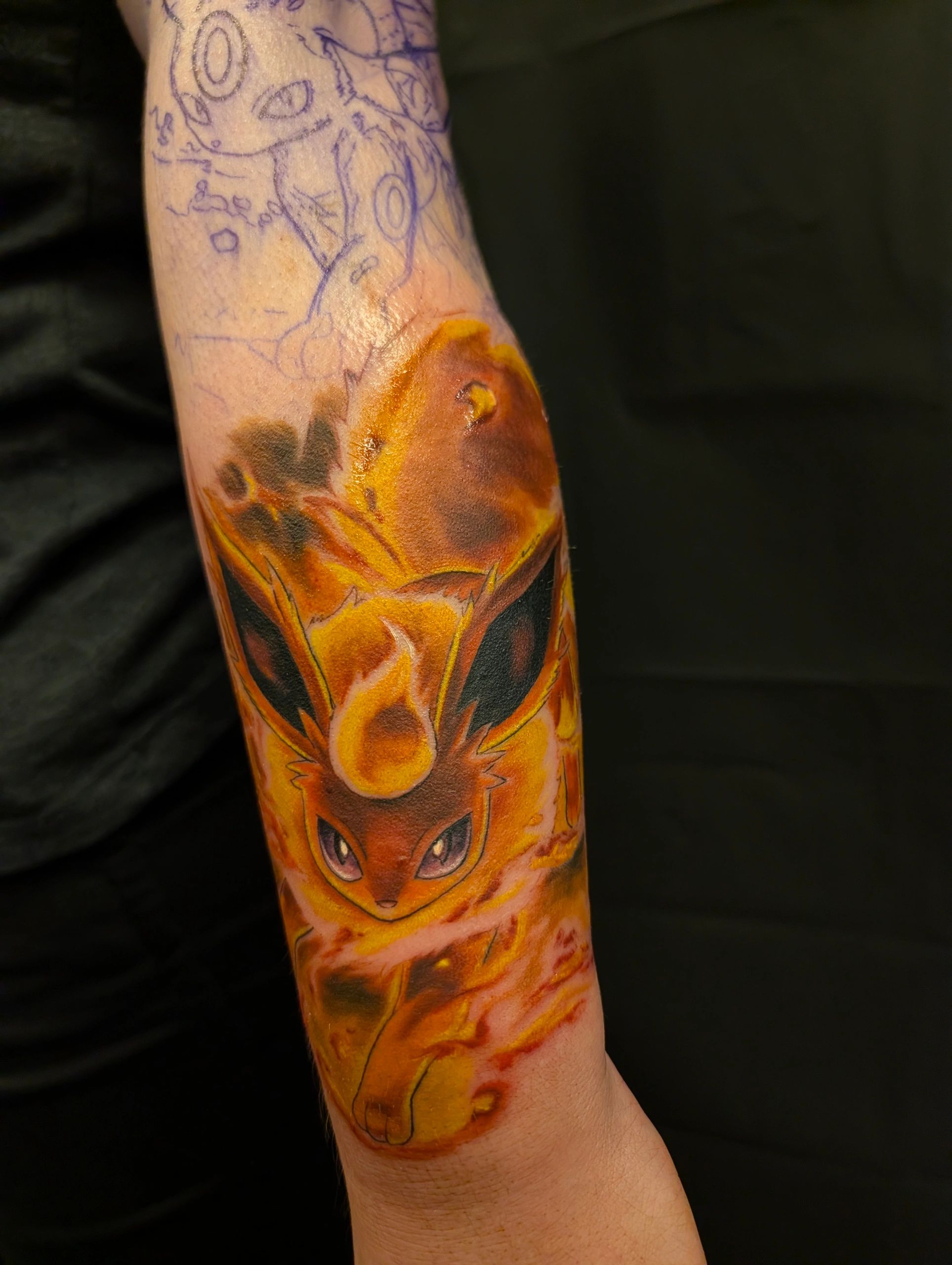 Flareon tattoo in progress on forearm.