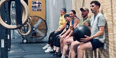 24/7 Gym Access at 327 Fitness in Pleasant Hill, Iowa. Members wall sit during class.