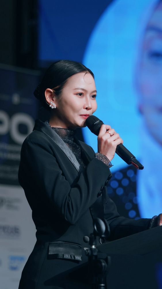 Professional Bangkok MC and trilingual event host speaking on stage at a corporate event in Thailand.