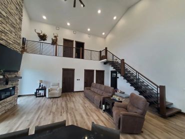 Spacious living room with staircase and mounted animal heads.