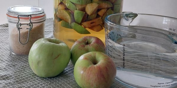 Apples , sugar and water are converted into apple cider vinegar.