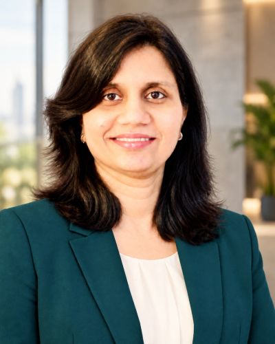 Professional woman in a green blazer smiling.