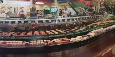 Wide display of various meats in a grocery store's meat section.