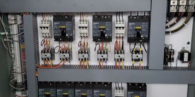 Industrial electrical control panel with circuit breakers and wiring.