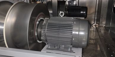 Industrial blower fan with electric motor inside a metallic enclosure.