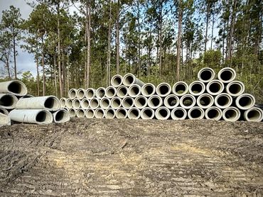 Stack of large concrete pipes outdoors.
