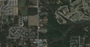 Aerial view of a residential area with forests and golf courses.