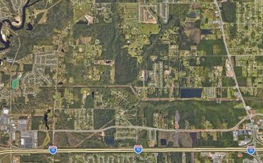 Aerial view of a suburban area with greenery and highways.