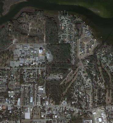 Aerial view of a residential and commercial area near a water body.