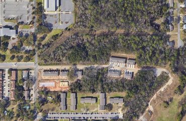 Aerial view of a residential area with trees and roads.