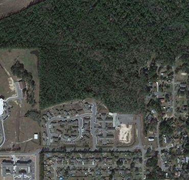 Aerial view of residential area near a forested region.
