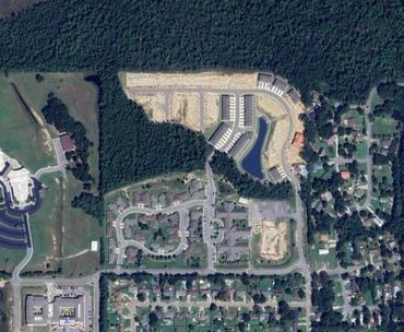 Aerial view of suburban neighborhood surrounded by forest.