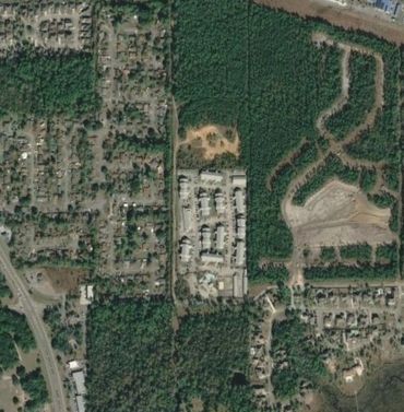 Aerial view of a residential area surrounded by trees and greenery.
