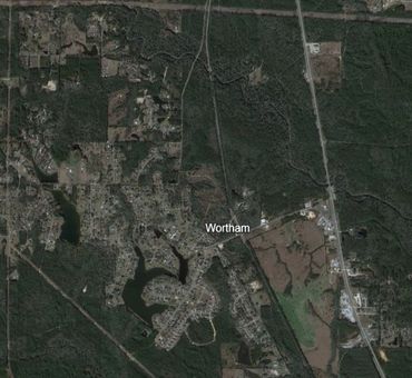 Aerial view of Wortham town surrounded by forests and roads.